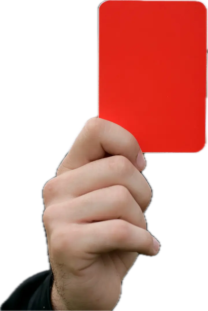 Eine Hand hält vor dem Ortsbild eine rote Karte hoch