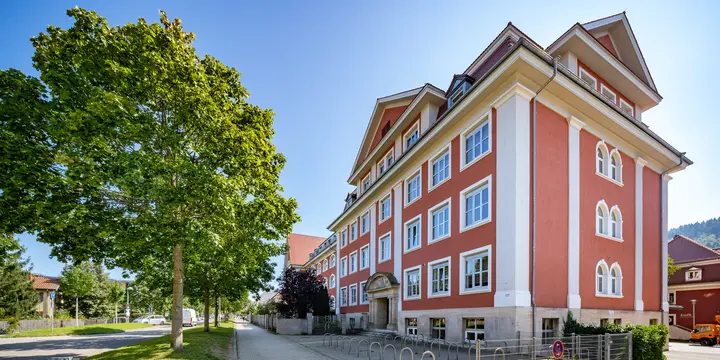 Die Emil-Thoma-Realschule in Freiburg, ein rot-weißes Schulgebäude unter blauem Himmel